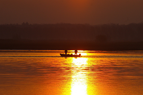 Boat on lake at sunset